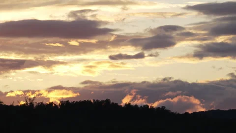 Scenic remote time lapse on moving clouds highlighted by low golden Sun abo.. Stock Footage 253932780