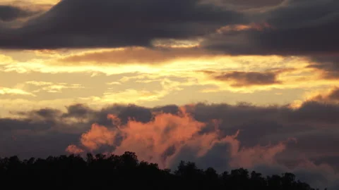 Scenic remote time lapse on moving clouds highlighted by low golden Sun abo.. Stock Footage 253934778