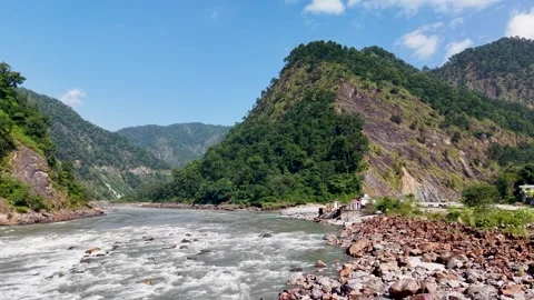 Scenic river flowing between green mountains with rocky banks Stockbeeldmateriaal 347767217