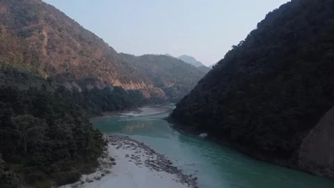 Scenic river flowing through deep valley between lush green mountain ranges Stock-Footage 335271011