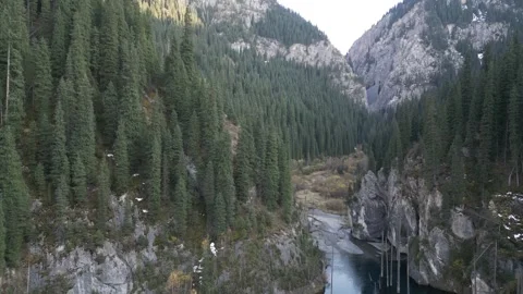 Scenic river flowing through lush forested mountains, camera pans right Stock-Footage 325024288