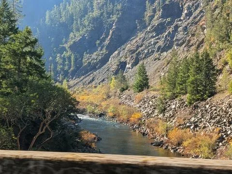 Scenic river flows through a forested valley beneath a bridge Фото