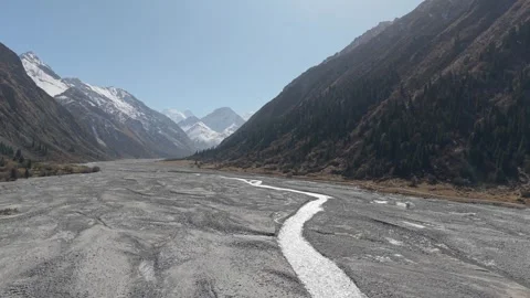 Scenic river flows through mountainous terrain with gradual camera zoom in Stock Footage 320395235