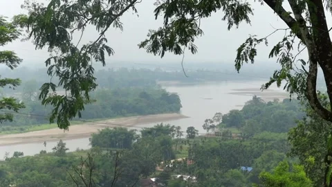 Scenic river landscape framed by lush forest and tree branches Vídeo Stock 337926969