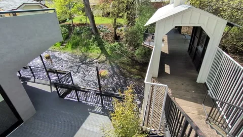 A scenic riverfront path leading to a historic covered bridge Stock Footage 337144290