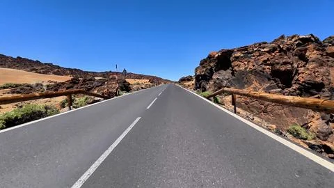 This is a scenic road located in a desert that features rocky terrain beneath a Stock Photos