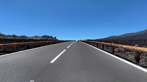 A Scenic Roadway Cutting Through a Dramatic Volcanic Landscape Beneath a Clear Stock Footage 311221868