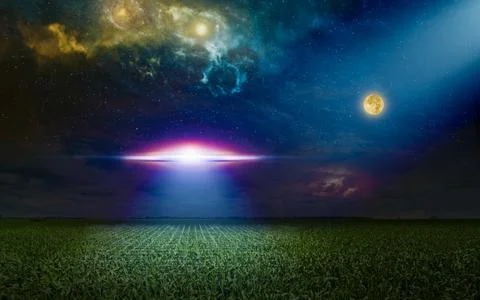 Scenic sci-fi image - ufo inspect green grass field with bright spotlight in  Фото
