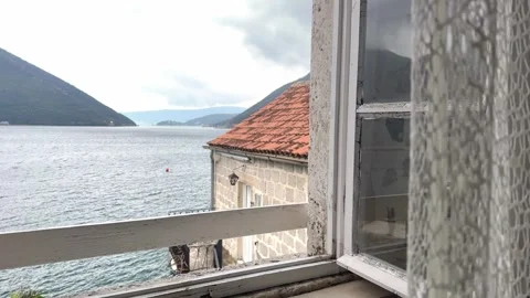 Scenic sea view through open window with traditional red roof houses in Mediterr Stock Footage 332403763