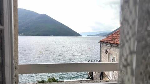 Scenic sea view through open window with traditional red roof houses in Mediterr Stock Footage 332403834