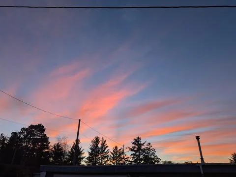 Scenic sky with dramatic blue clouds tinted pink and red Stock Photos