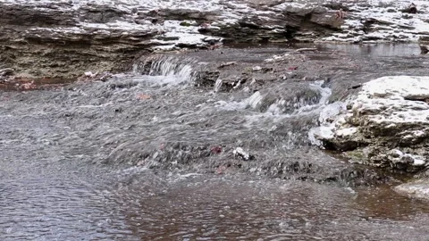 Scenic Small Waterfall Cascading Over Rocks in Winter Stock Footage 327101632