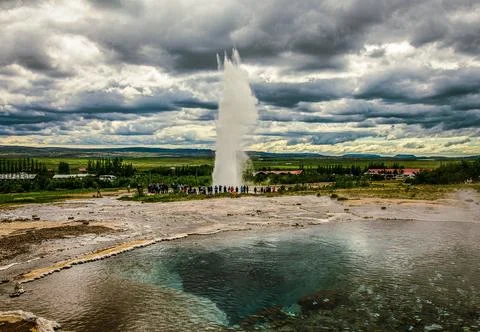 Scenic of a steaming geyser exploding in Iceland under a cloudy sky Foto stock