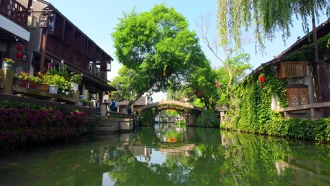 Scenic Stone Bridge Over River With Traditional Buildings and Lush Greenery Видео 336770877