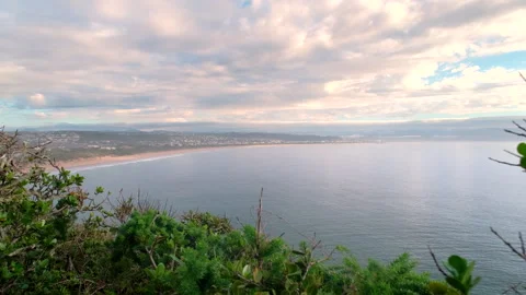 Scenic sunrise cloudscape with view from Robberg toward Plettenberg Beach Stock Footage 334659096