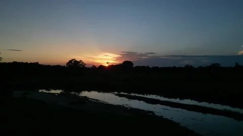 Scenic sunset over river and countryside with golden horizon and silhouette.. Video stock 344694229