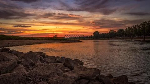 Scenic sunset sky and cloudscape over a river with a bridge Stock Photos