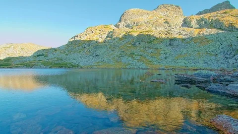 Scenic sunset time lapse above mountain lake and high rocky peak Video stock 80165157