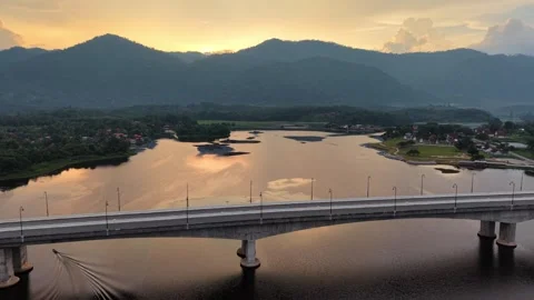 Scenic sunset view of calm river with modern bridge and mountain landscape Video stock 339845344