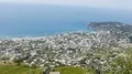 Scenic town spread along seacoast facing blue calm water on sunny day, panorama HD Footage