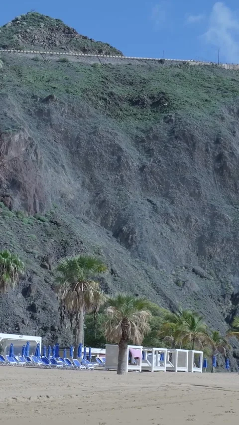 Scenic tropical beach at the base of a steep cliff Stock-Footage 329866242