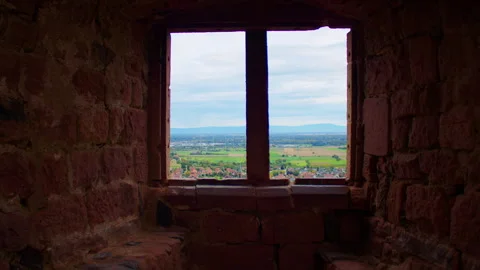 A scenic valley view framed by an old stone window in a historic building. Video stock 310812982