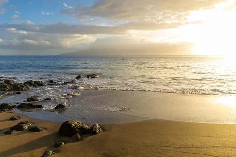 Scenic view of a beach at sunset with an array of rocks dotting the shoreline. H Stock Photos