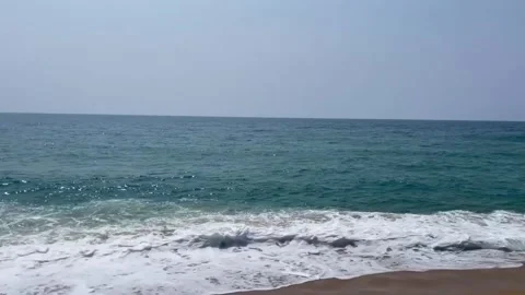 Scenic view of blue ocean waves crashing on a sandy beach shoreline Vídeos de archivo 334084330