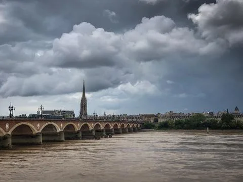 Scenic view of Bordeaux river bridge with St Michel cathedral and storm sky Stock-Fotos