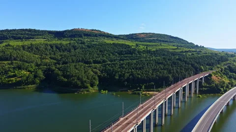 Scenic view of a bridge over a river with green hills in the background during a Stock Footage 340762616