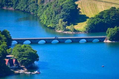Scenic view of a bridge over a river with trees and fields in the background Stock Photos