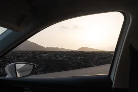 Scenic view from a car window at sunset near mountains and lava fields Stock Photos