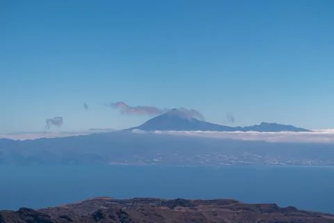 Scenic view on cloud covered volcano mountain peak Pico del Teide on Teneri.. Stock Photos