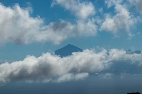 Scenic view on the cloud covered volcano mountain peak Pico del Teide on Te.. Stock Photos