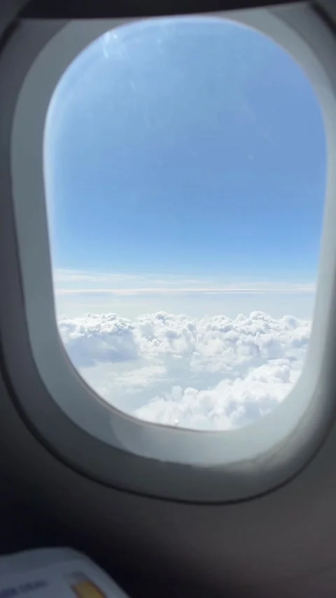 Scenic view of clouds and blue sky from an airplane window Video stock 336400352