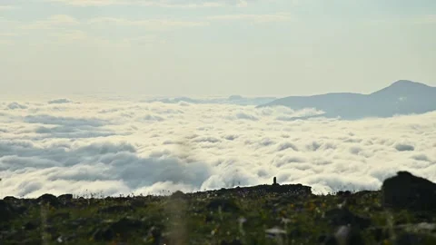 Scenic view of clouds rolling over mountains with rocky foreground elements Stock Footage 341355396