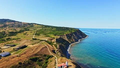 Scenic view of a coastal area with cliffs and green hills under a clear sky in a Stock Footage 341119532