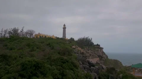 Scenic view of a coastal lighthouse on a cloudy day in a serene location Stock Footage 310851671