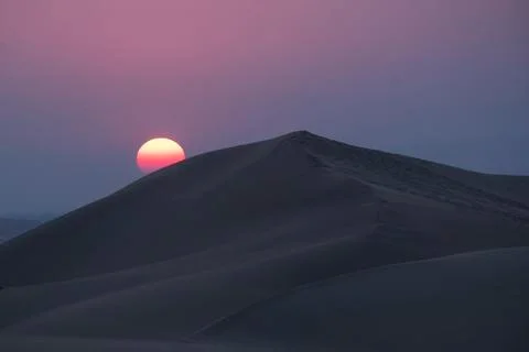 Scenic view of desert against dramatic sky at dusk Foto stock