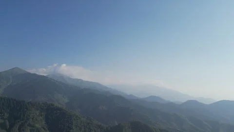 Scenic view of distant, layered mountain ridges under a hazy blue sky. Stock Footage 341270394