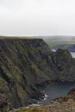 Scenic view of dramatic coastal cliffs and the sea on a cloudy and foggy summ Stock Photos