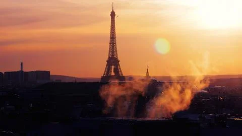 Scenic view of Eiffel tower on orange sunset sky background with smoke in the fo Foto stock