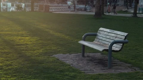 Scenic view of an empty bench with peopl... | Stock Video | Pond5