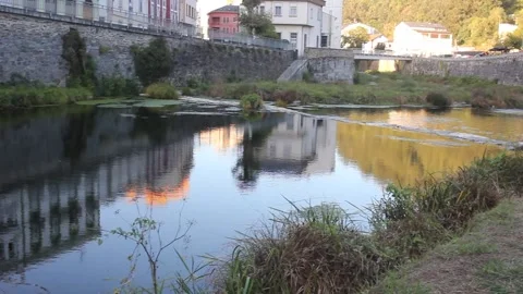 Scenic view of the Eo river reflecting town buildings and hills in A Ponteno 库存影片 346319188
