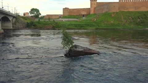 Scenic view of a fast river current with an ancient fortress on a hill Stock Footage 336388829