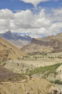 Scenic view of flowing river in between  rocky mountains with clouds in the sky  写真素材