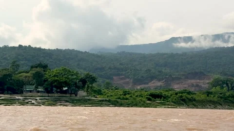 Scenic view of a flowing river with lush green forest and misty mountains i.. Stock Footage 339369294