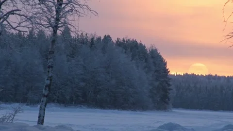 Scenic view of a glowing winter sunset casting a warm orange light over a f.. Stock Footage 341871957