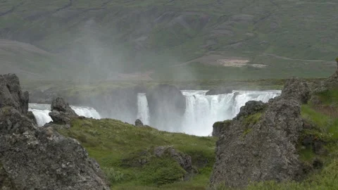 Scenic View of Godafoss Waterfall Behind Green Hills in Iceland 4K Slow Motion Stock Footage 339811026