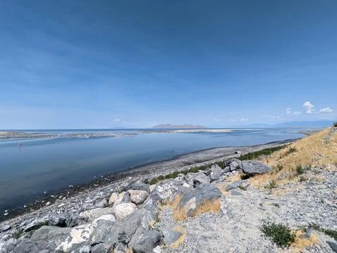 Scenic View of the Great Salt Lake with Rocky Shoreline and Clear Blue Sky. Stock Photos